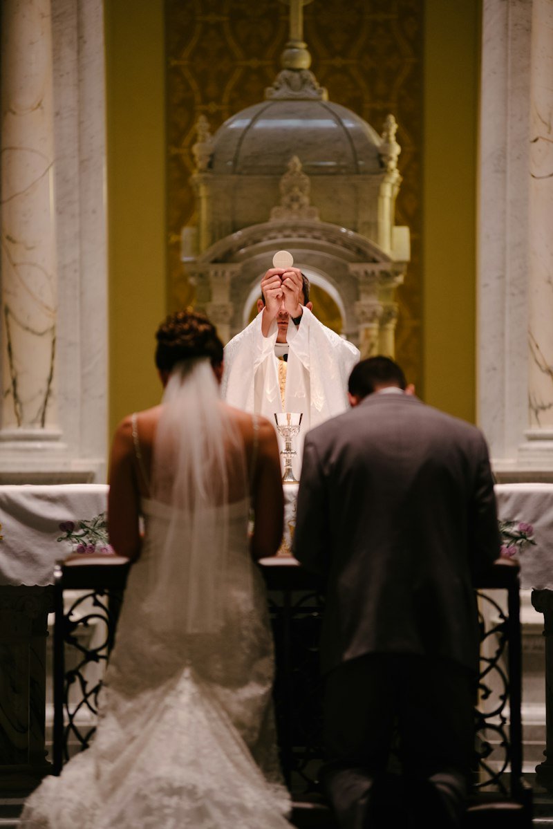 Bride and groom kneeling at the altar during a Christian church wedding ceremony