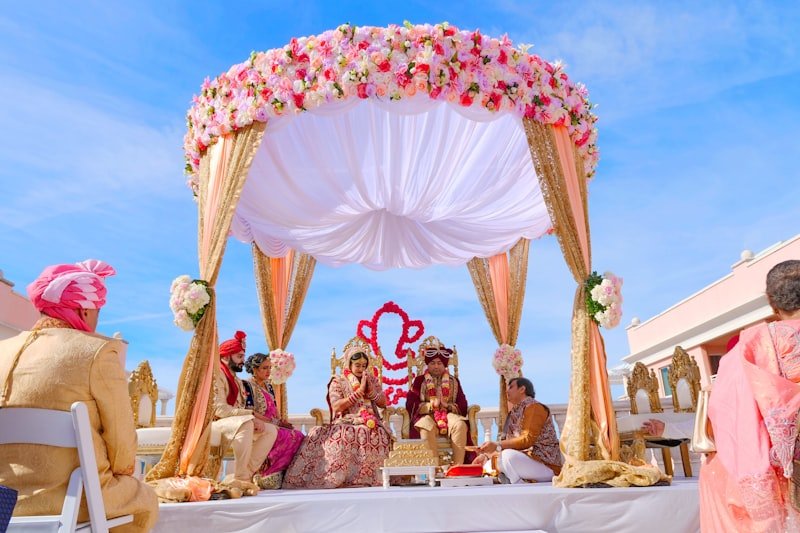 Indian wedding ceremony under a floral mandap with Ganesha